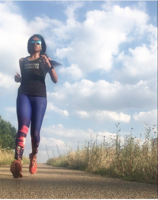 indian woman running in a green outdoor open space