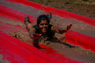 indian woman covered in mud down a slide